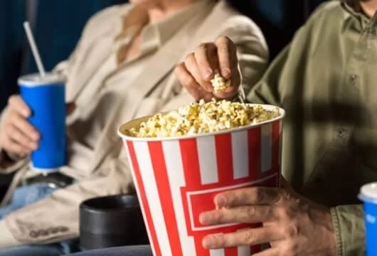 Close-up of man eating popcorn at a movie theater
