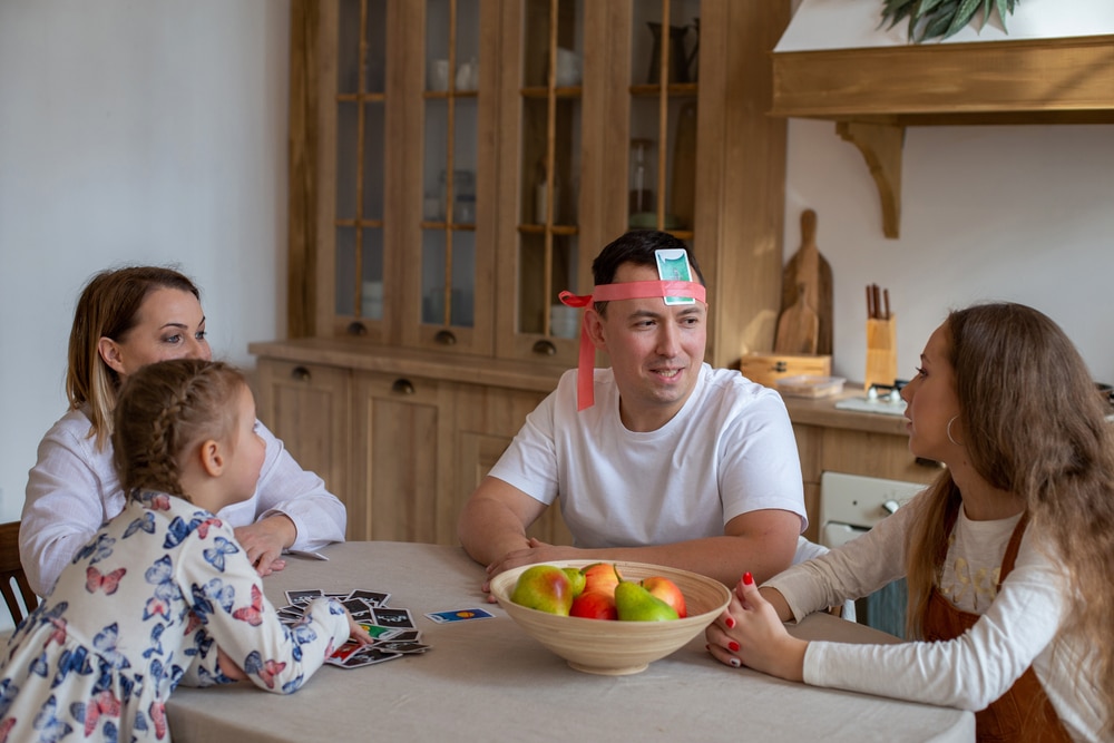 Family playing a game at the kitchen table