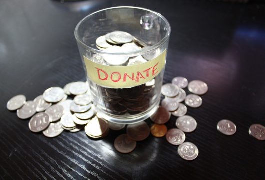 Donation cup filled with coins