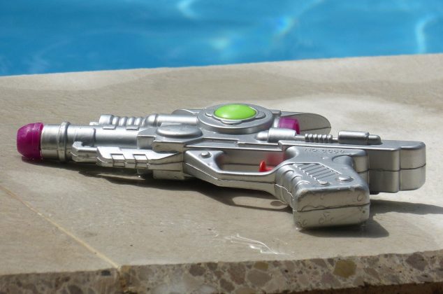 Water gun toy sitting on the edge of a pool