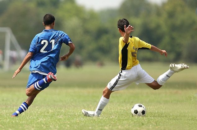 Two young men playing football (soccer)