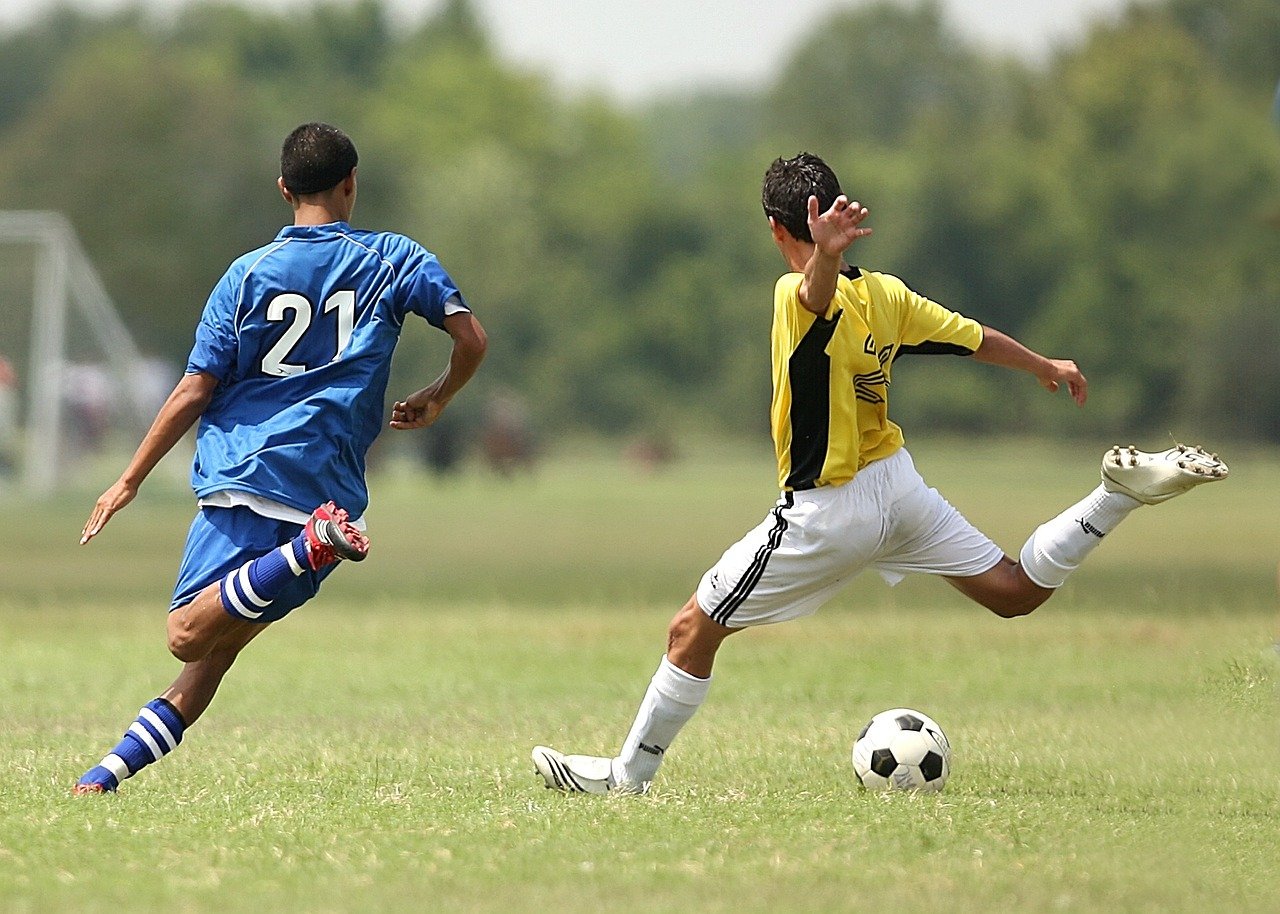Two young men playing football (soccer)