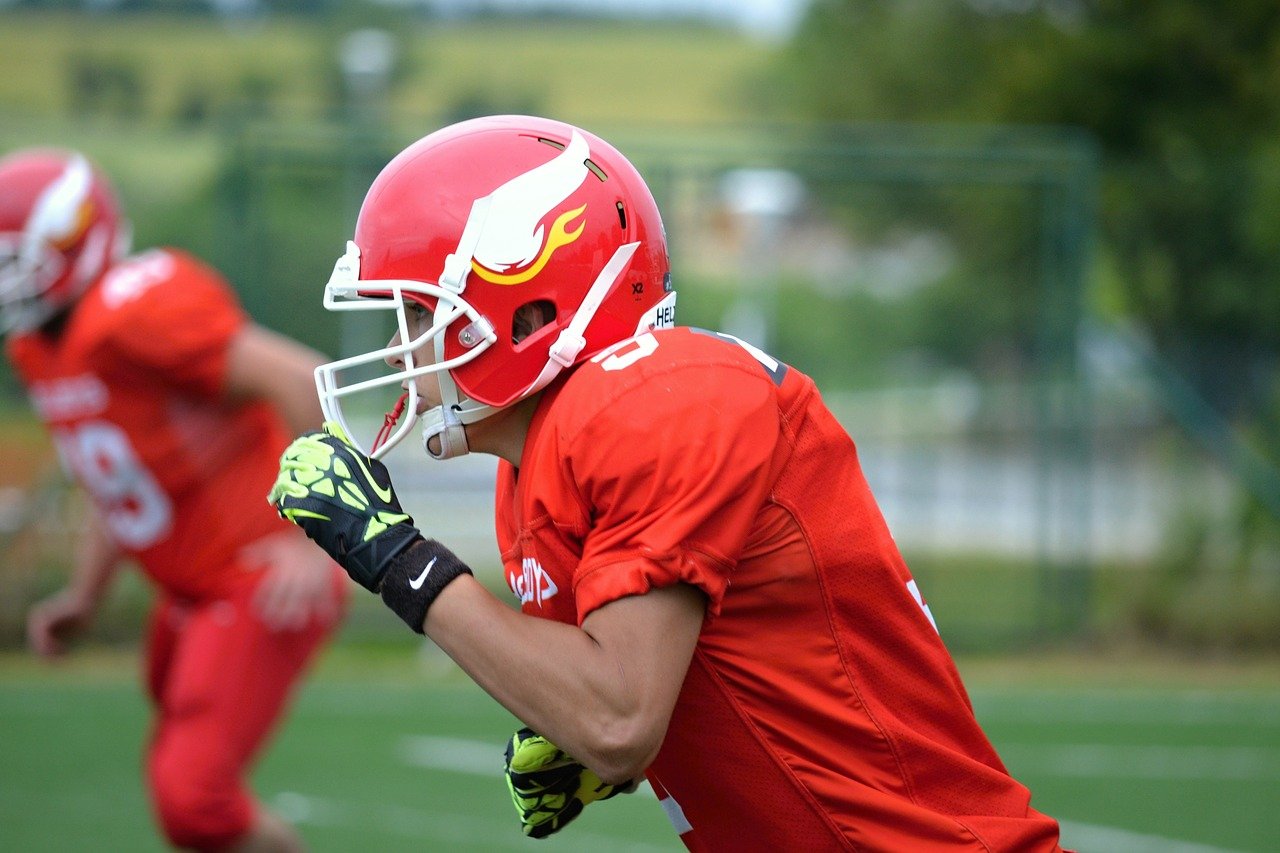 Two young men in red uniforms playing football