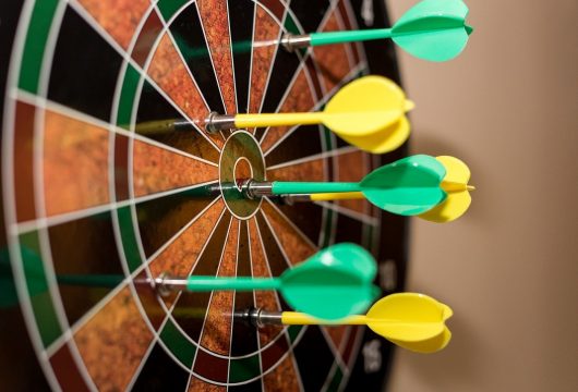 Dartboard with green and yellow darts