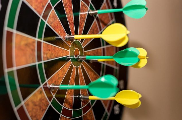Dartboard with green and yellow darts