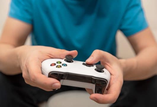 Close-up of man's hands playing NBA 2K on Xbox