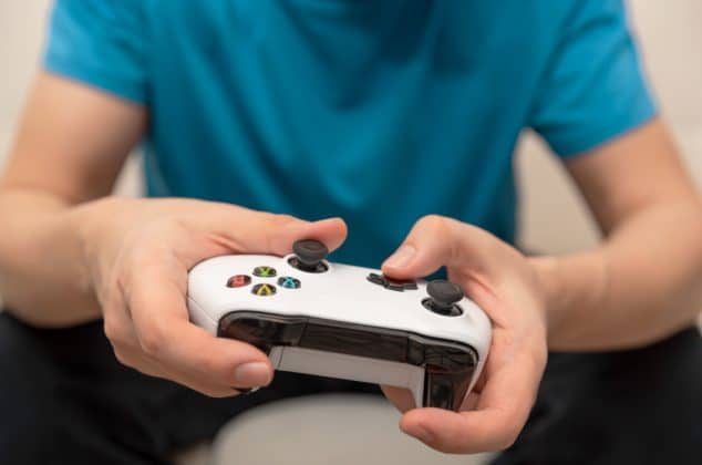 Close-up of man's hands playing NBA 2K on Xbox