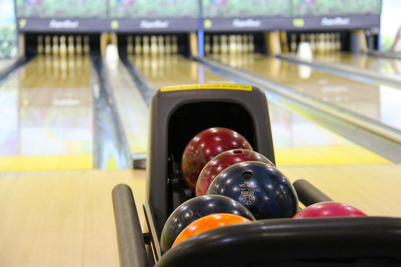 Bowling balls lined up in front of alley lanes