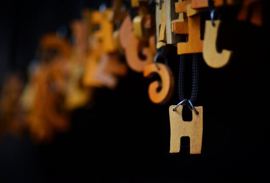 Wooden letter "H" hanging on a wire