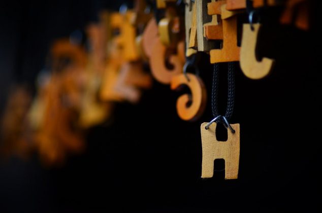 Wooden letter "H" hanging on a wire