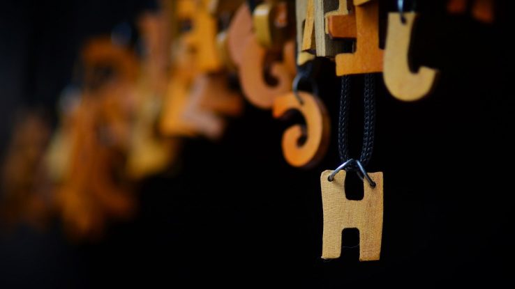 Wooden letter "H" hanging on a wire