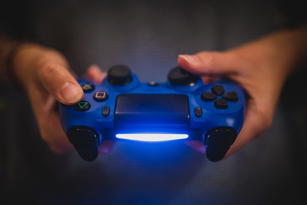 Hands holding a blue video game controller