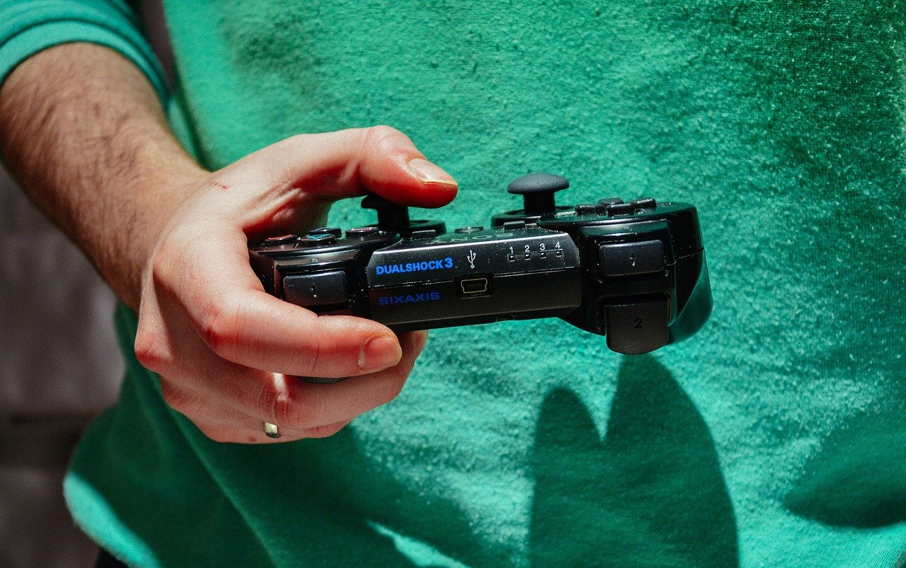 Man in green shirt holding a video game controller