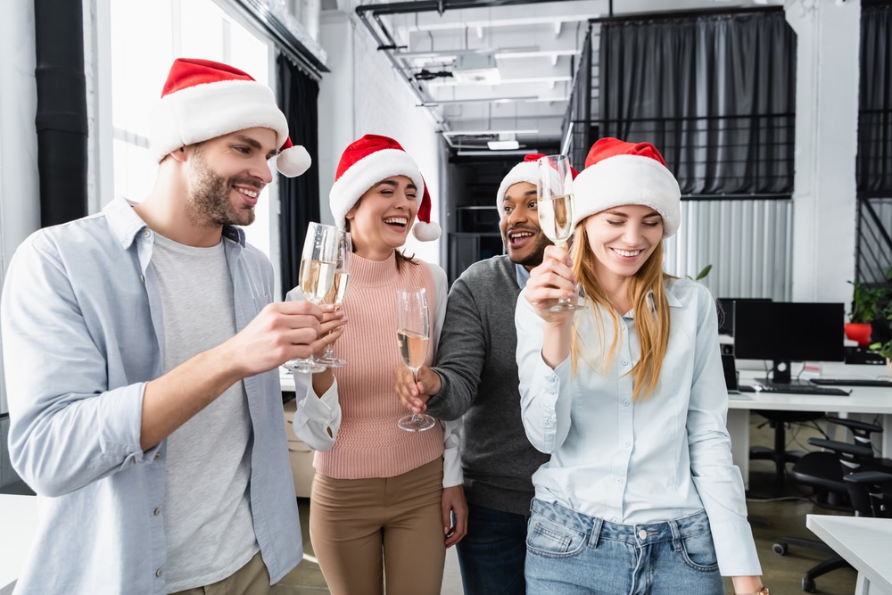 Four members of a christmas team wearing santa hats