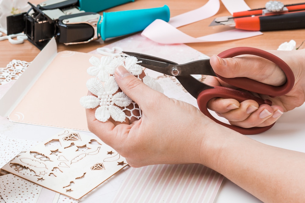 Woman cutting flowers to decorate a scrapbook