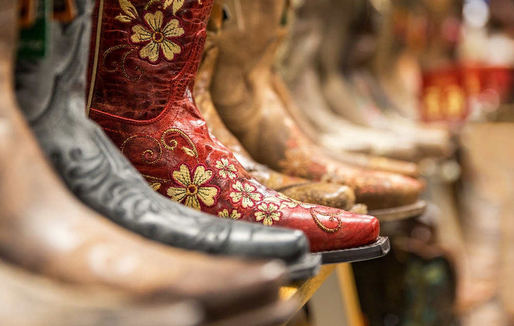 Cowboy boots lined up on a shoe rack
