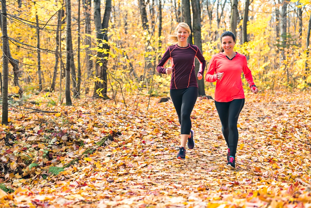 Two women running during a fall fitness challenge