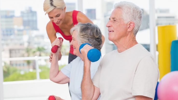 Two seniors and a trainer in a senior fitness class