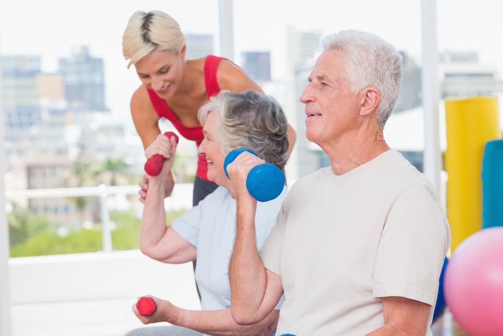 Two seniors and a trainer in a senior fitness class
