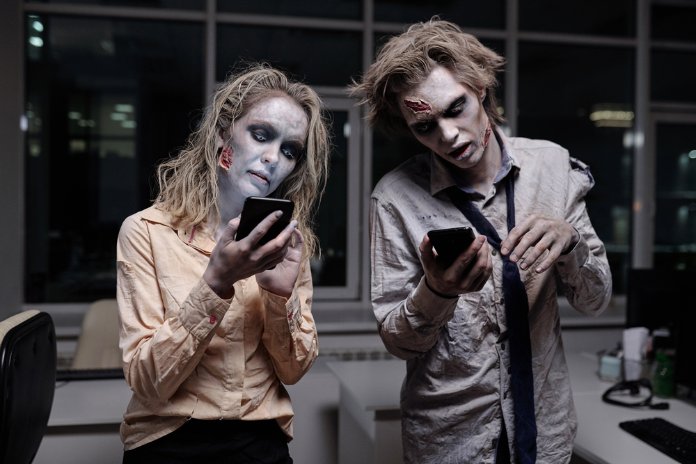 Two zombies using smartphones to find zombie team names