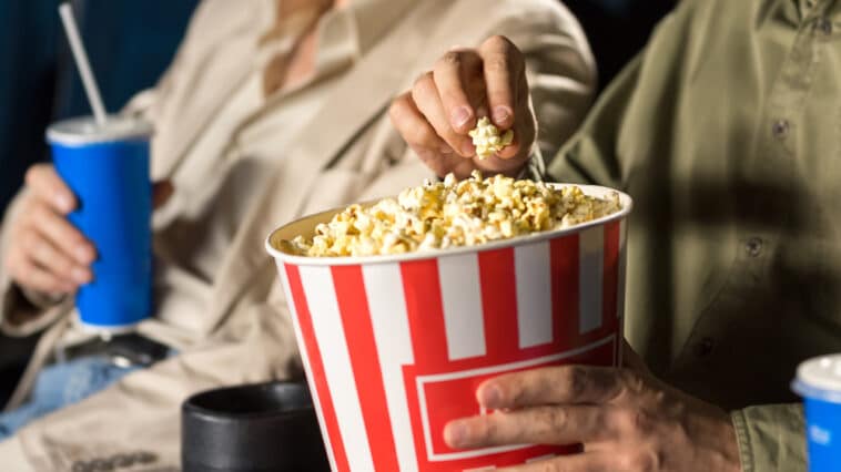 Close-up of man eating popcorn at a movie theater