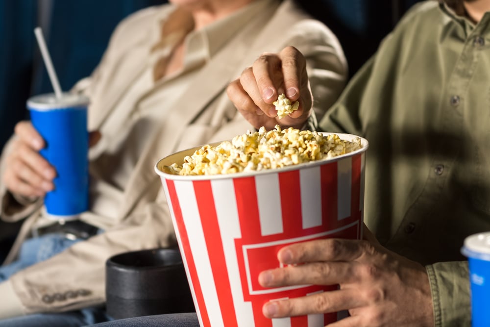 Close-up of man eating popcorn at a movie theater